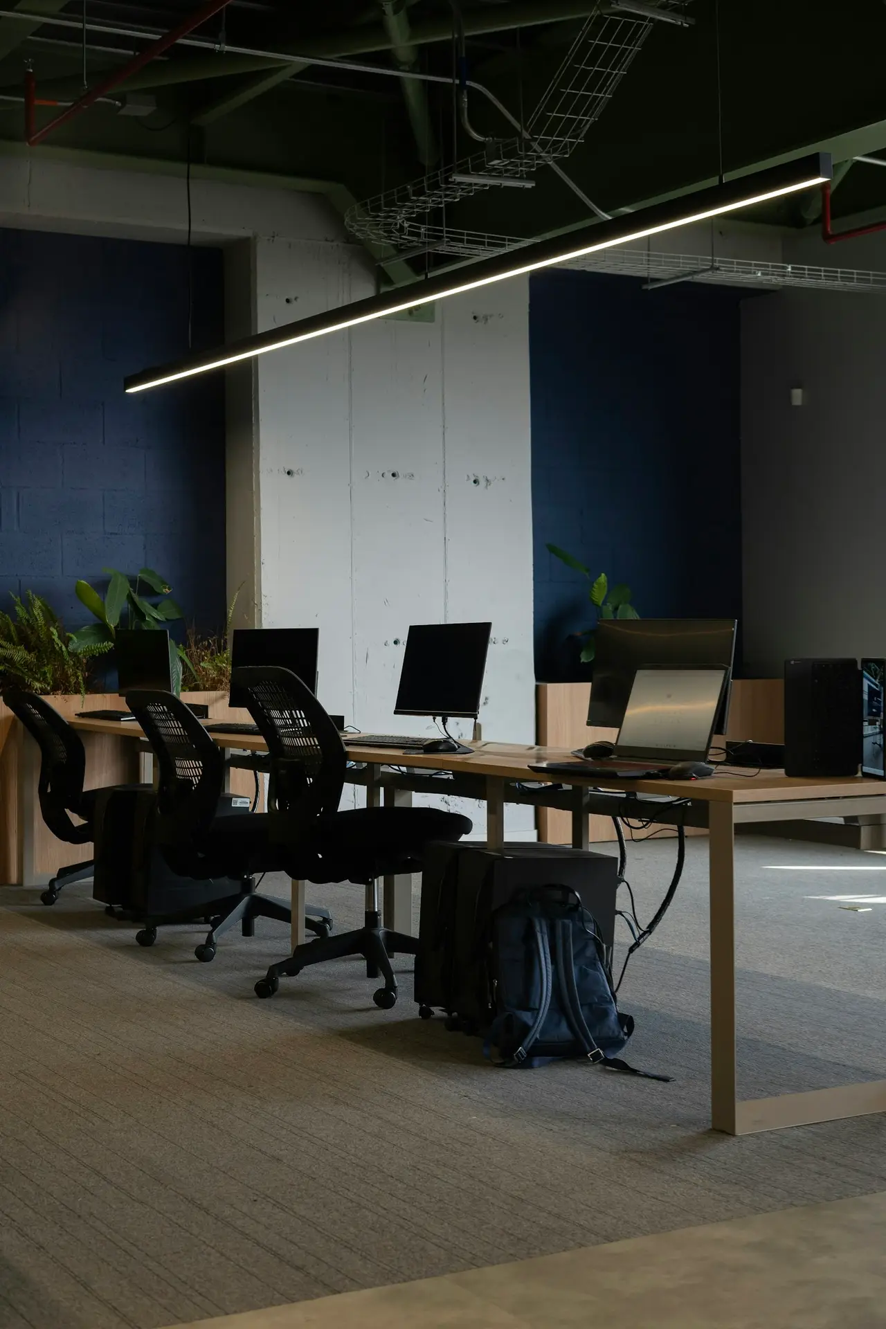 Puestos de trabajo con sillas y pantallas en un espacio compartido vacío